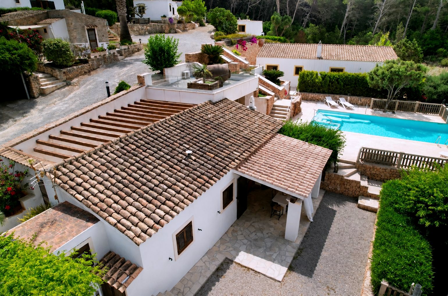 Salón con muro de piedra original y cocina con barra de madera